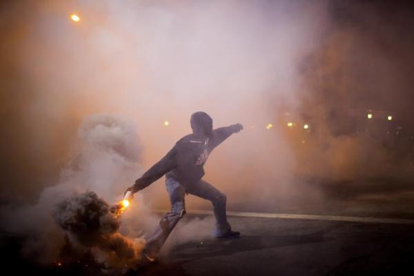 A Baltimore protester tosses a gas canister back at the police. Source: IBTimes.com